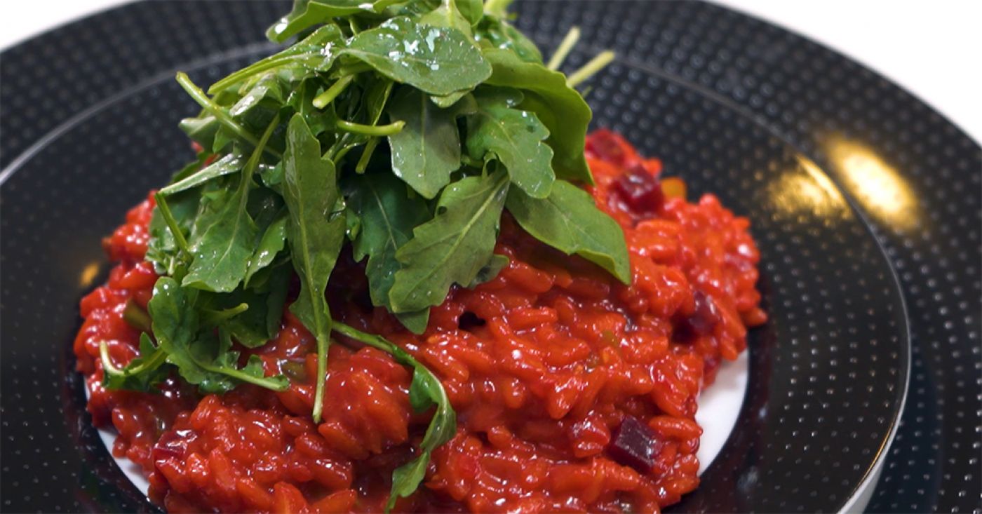 Red risotto with green asparagus and arugula
